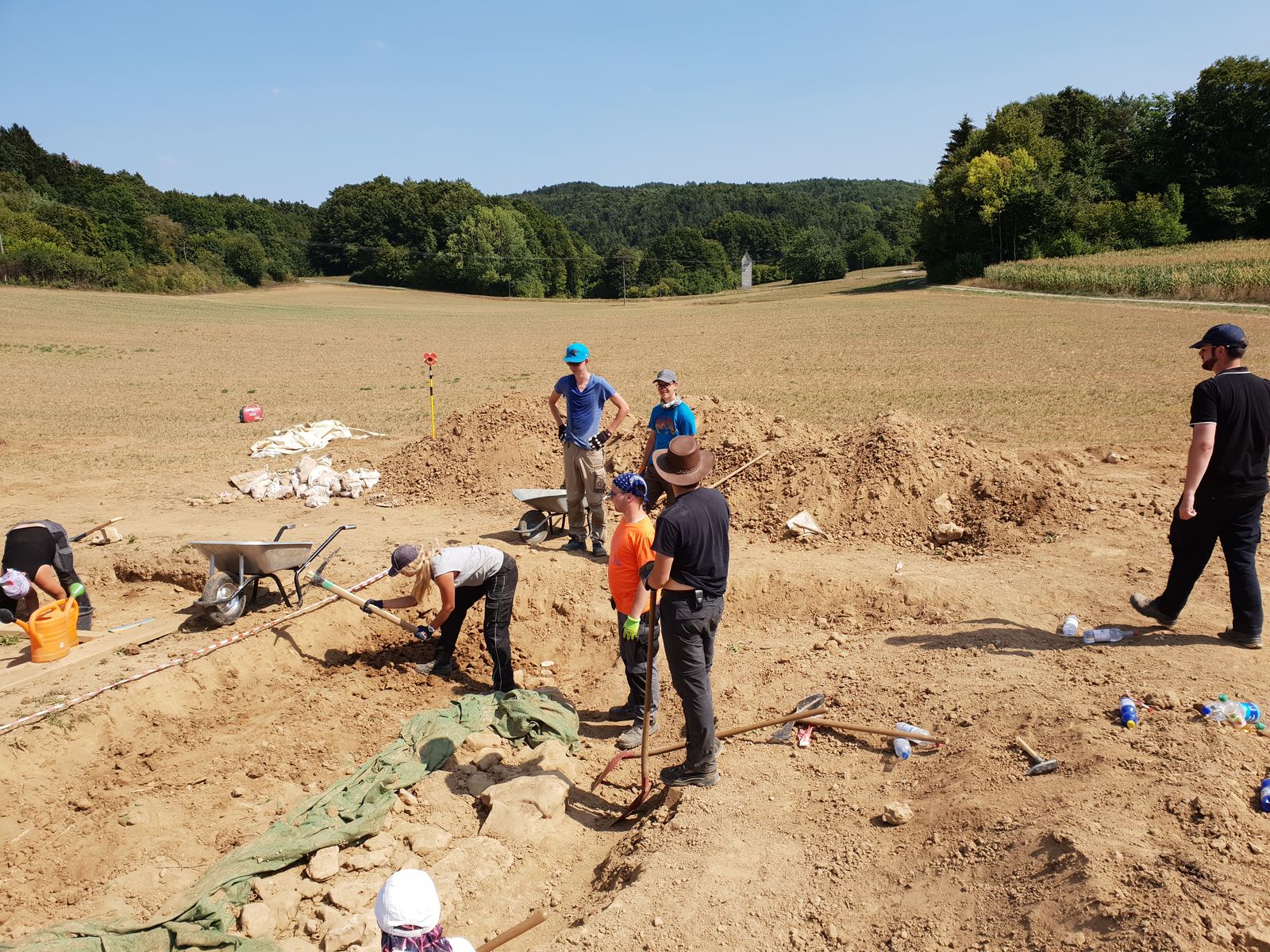 Baustelle im öffentlichen Dienst: Studierende beobachten ihre Kommilitonin beim Arbeiten mit der Spitzhacke.