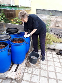 Die gerottete Rinde wird aus den Fässern geholt und in Wannen zum Auswaschen gepackt (im Foto: I. Hohenester).