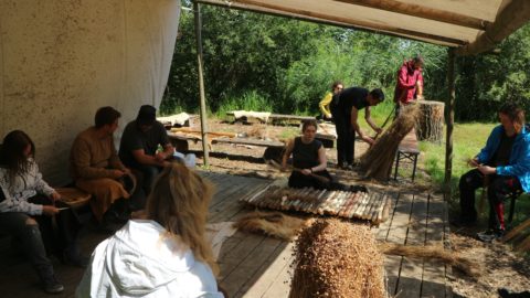 Leinverarbeitung: Verschiedene Arbeitsprozesse in einem Bild: Brechen der Fasern mit dem Schwert, Gewinnung der Samenkapseln, Glätten.