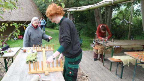 Weben: Hildegard Igel (hinten links) zeigt das Abmessen der Kettfadenlängen.