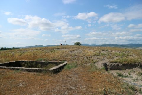 Ein sozialistischer Fundamentrest und eine archäologische Ausgrabungsfläche am Rand des Tells von Mashaveras Gora.