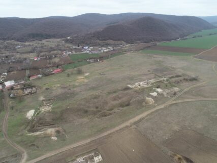 Blick über die antike Stadt (L)ibida bei Slava Rusa. Die eine Hälfte ist unter Gras, die andere unter dem heutigen Dorf