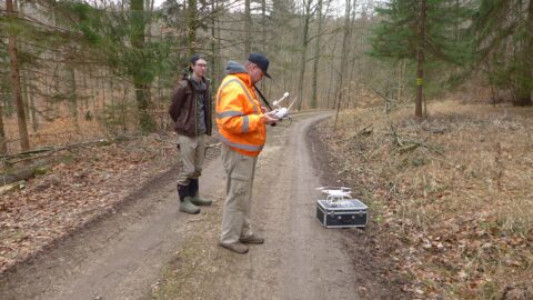 Überfliegung mit der Drohne: Der richtige Startplatz will im Wald gut gewählt werden. Einer arbeitet (C. Mischka) der andere gibt hilfreiche Bemerkungen (M. Trodler).
